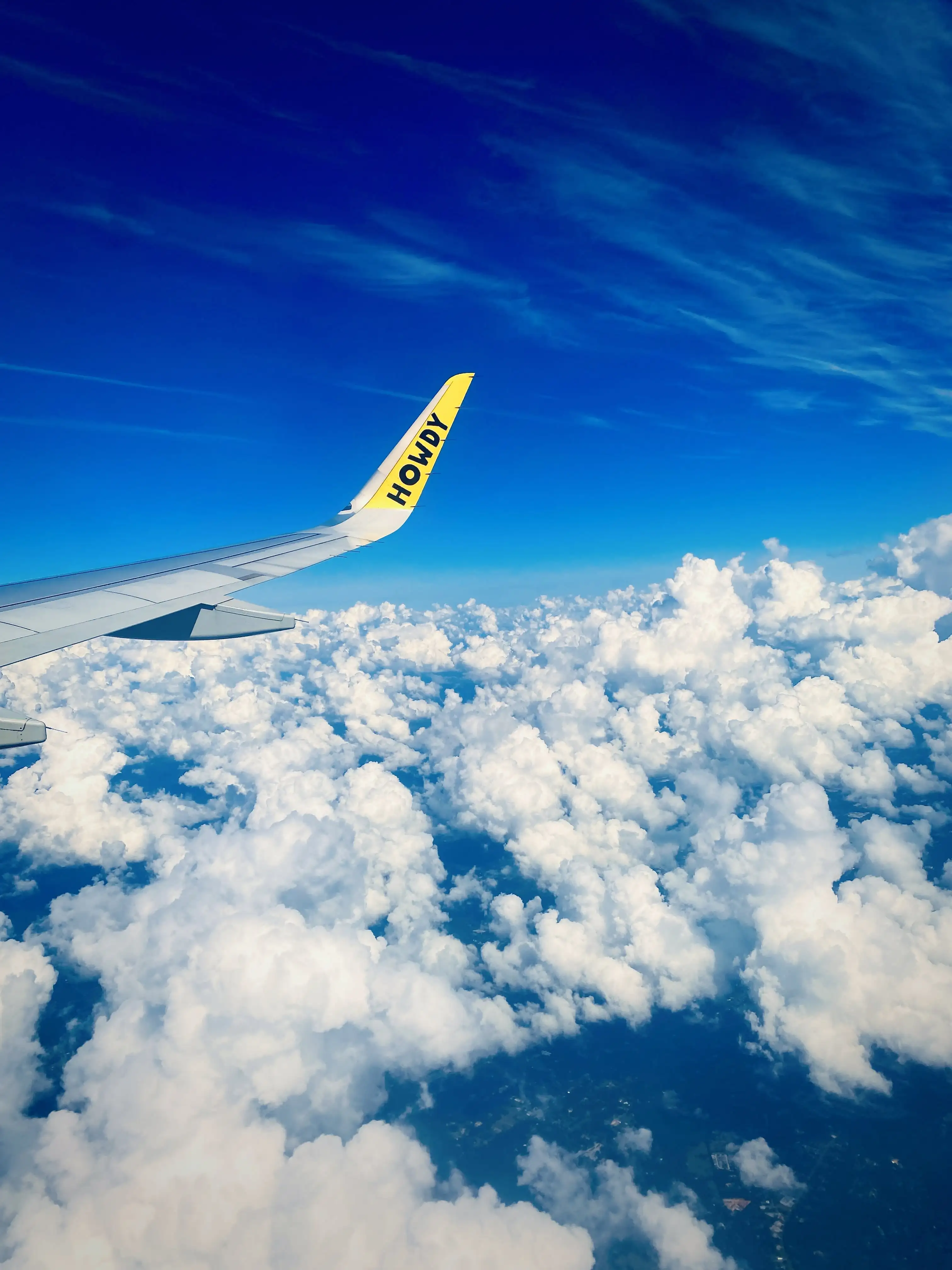 blue sky above clouds with wing of plane