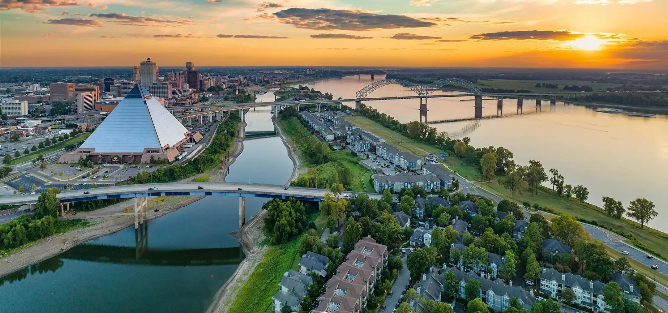 sunset over a city with a river with bridges